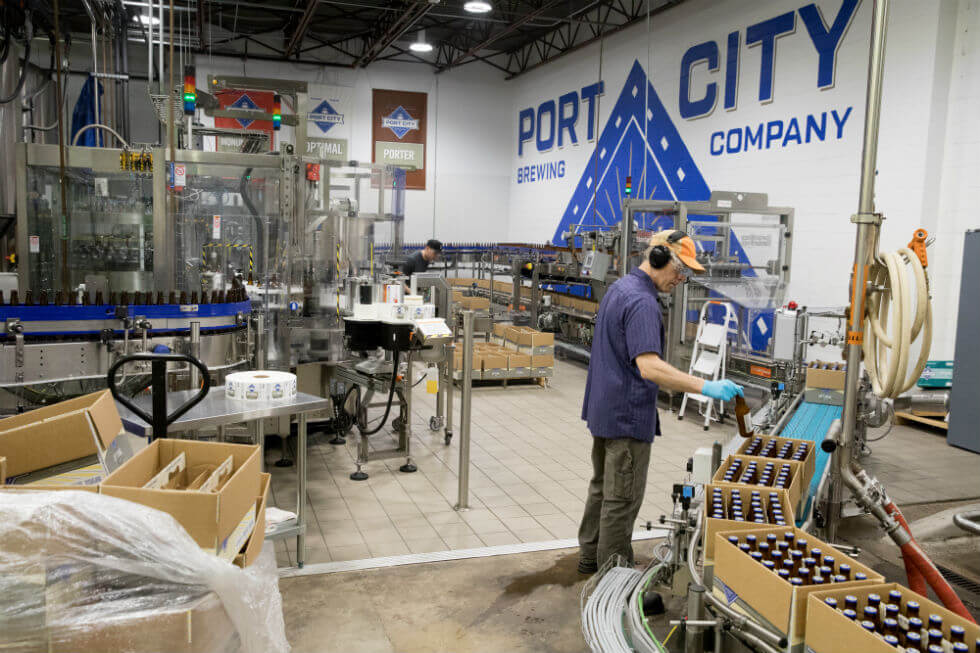 Pete Wheeler, Production Technician and Bottling Line Operator inspects bottles of Optimal Wit.