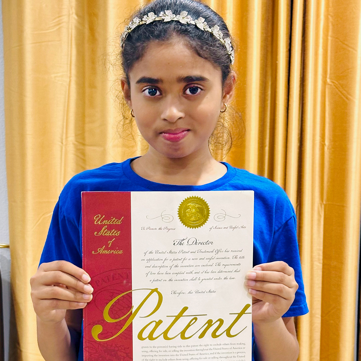 Young inventor Vennela Attili with her patent for the Happy Sleep doll.