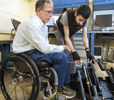 Seated in his wheelchair Rory Cooper supervises a lab assistant