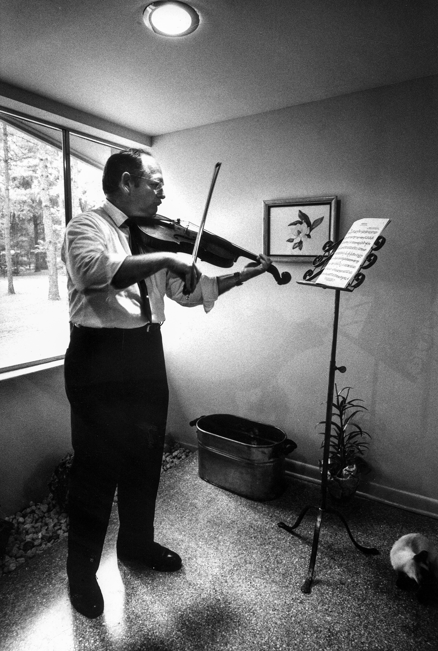 Man reads sheet music while playing a violin