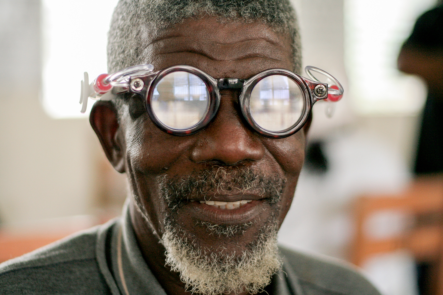 Close-up photo of elderly man wearing fluid-filled self-adjustable prescription eyeglasses.