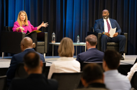 USPTO Director Kathi Vidal (on the left) and Deputy Director Derrick Brent (on the right) are seated next to each other on July 18 at an agencywide town hall. They both face the audience, and Vidal is speaking and gesturing. The event was held in the Clara Barton Auditorium on the headquarters campus in Alexandria, Virginia. 