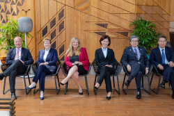 Six leaders from top five intellectual property offices sit side by side with their right leg crossed over their left