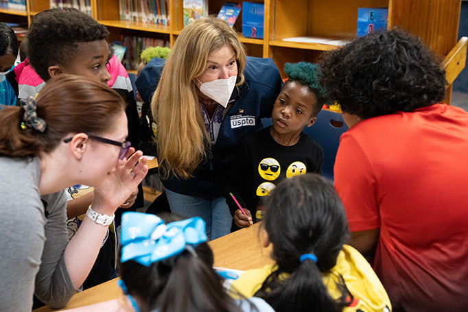 Director Vidal speaks at eye level with young students 