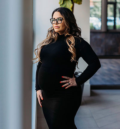 Maria Atunduaga standing in a power pose with her hand on her hip while looking away from the camera