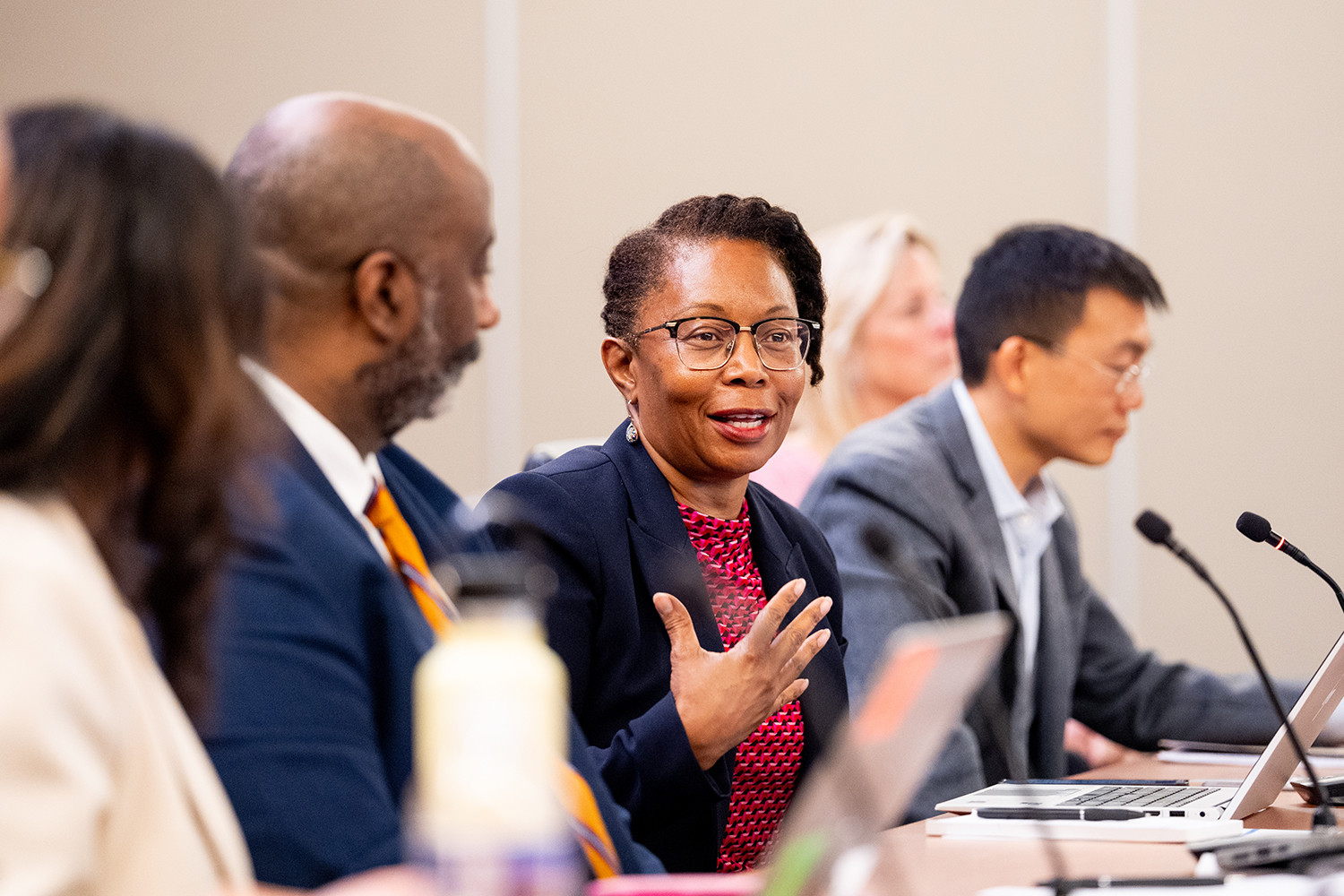 Loletta Darden speaks while gesturing at a Patent Public Advisory Committee meeting, with USPTO Deputy Director Derrick Brent and PPAC Vice Chair Charles Duan. USPTO’s Michael Connor took this photo.