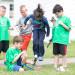 Several Camp Invention students gather outside to launch a bottle rocket. One holds the rocket while