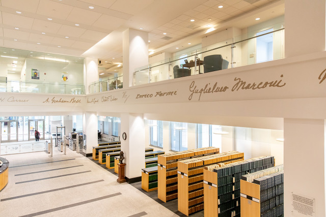 View of the front section of the Public Search Facility, showing a balcony with inventors' signatures and stacks of bound trademarks.