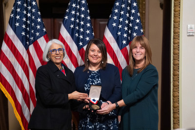 Annaliesa Anderson and Alejandra Gurtman, of Pfizer, and White House science and technology advisor Prabhakar pose with a medal.