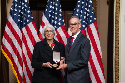 David R. Walt and White House Office of Science and Technology Policy Director Arati Prabhakar smile and show a medal.