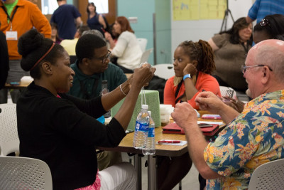 Several teachers sit around table working on future activites for their classrooms