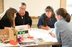 four women at NSTI sitting around the table engaged in active discussion