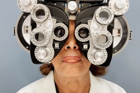 Dr. Patricia Bath faces forward with most of her face covered by the optical trial lens frame that optometrists use to determine a patient’s glasses prescription. 