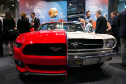 NIHF Museum exhibit featuring two halves of a Ford Mustang, a white half from 1965 and a red half from 2015.