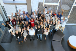 Group of teachers looking up with their hands held high