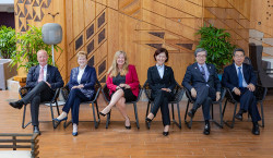 Six leaders from top five intellectual property offices sit side by side with their right leg crossed over their left