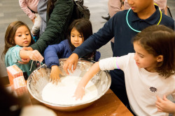 children with hand in a large mixing bowl making slime