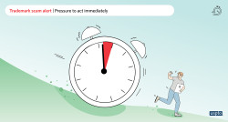 A graphic of a large clock with the alarm going off rolling downhill towards a person holding a document with the Trademark symbol on it. The words Trademark scam alert – pressure to act immediately appear at the top of the image.