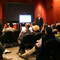 Photo of adults sitting in a conference room listening to a speaker.