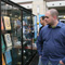 Photo of a man looking in a glass case displaying several pictures of the Trademark Registered symbol design.