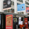 Photo displaying several standing banners on the atrium floor with banners hanging above.